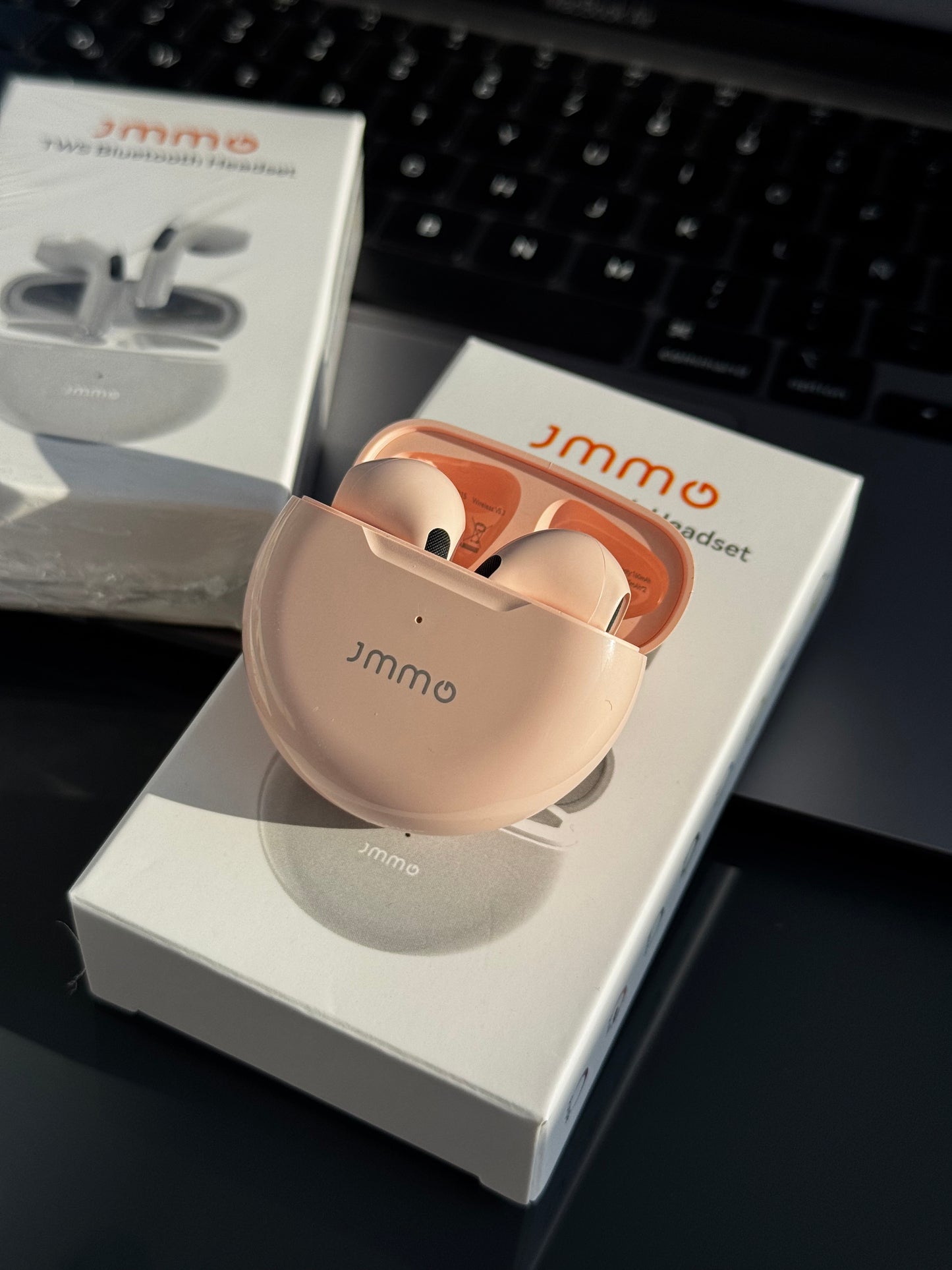 Audífonos inalámbricos JMMO (básicos), en tono rosa nude y blanco.